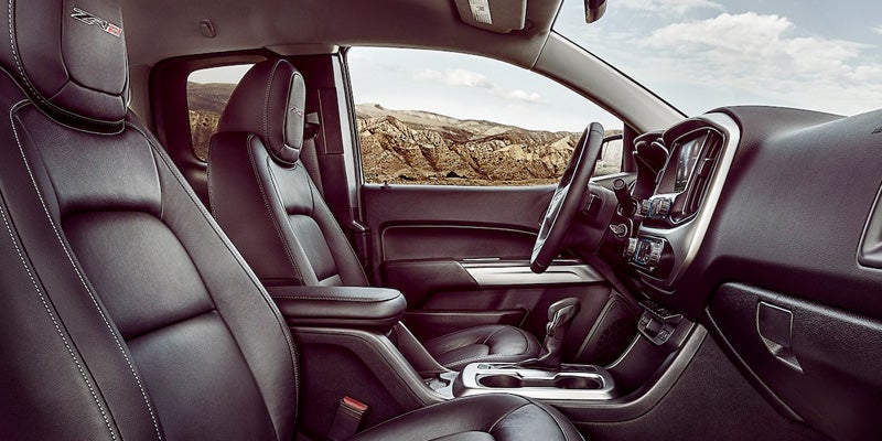 Interior view of a 2022 Chevrolet Colorado truck featuring black leather seats, center console, and dashboard with touchscreen display