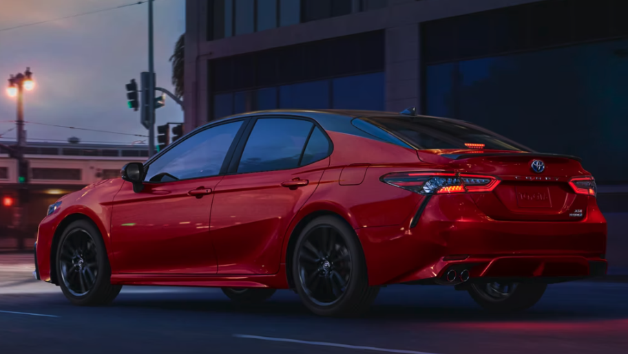 Image of a red 2023 Totoa Camry parked beside a building on the street
