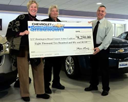 Chevrolet of Smithtown owner holding a check donated to a group in the community